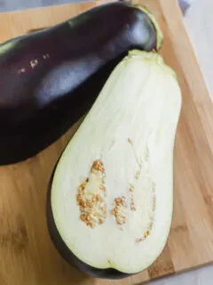 can dogs eat eggplant? - eggplant sliced in half on a cutting board