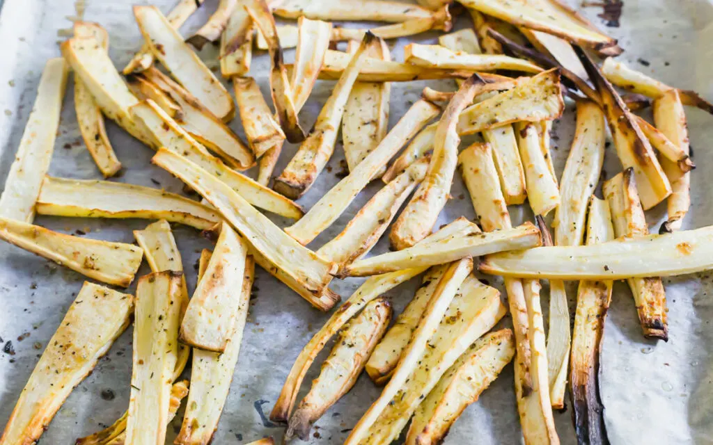 Roasted parsnip fries on a baking sheet.