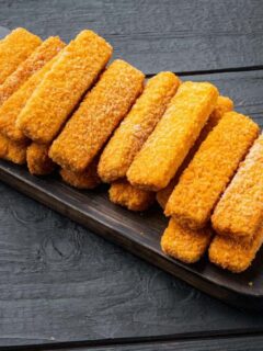Fried fish sticks on a wooden tray.