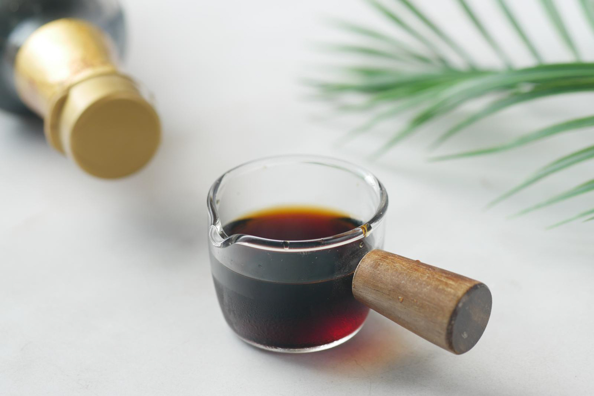 Small glass with soy sauce in it.