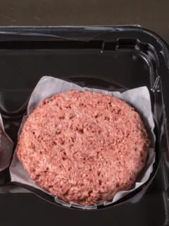 Two beef burgers in a tray on a table.