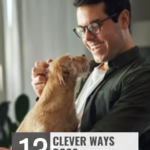 A man wearing glasses smiles at a small dog sitting on his lap at a desk. Text reads: "WHATCANMYDOGEAT.COM &ndash; 13 Clever Ways Dogs Manipulate Us and how to help your dog live longer.